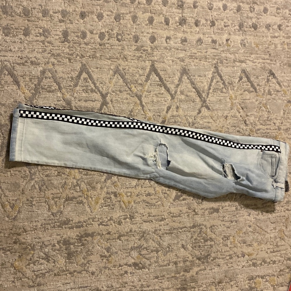 Blue jeans with checkerboard side stripes.